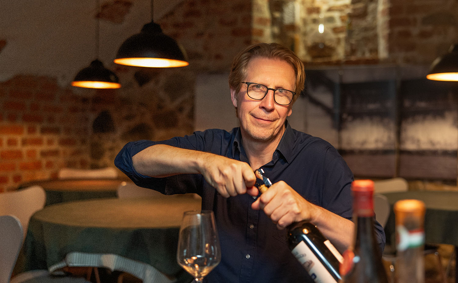 Vincent Arrhenius öppnar vinflaskor och förbereder en provning i en vacker vinkällare i Gamla stan.